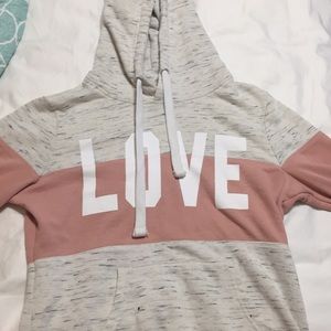 A pink and white hoodie with the word love on it